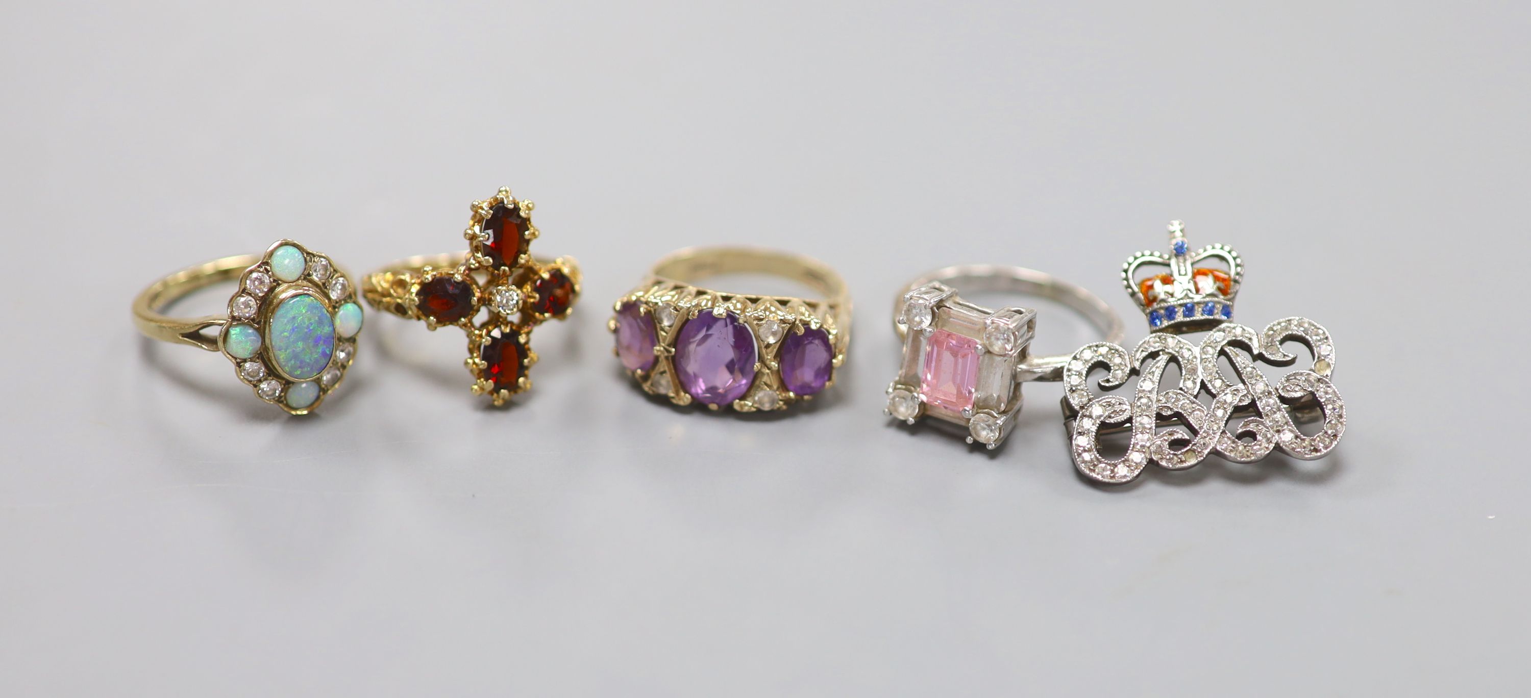 Four assorted modern 9ct gold and gem set dress rings, including amethyst and white opal, gross 16.2 grams and a paste set white metal brooch